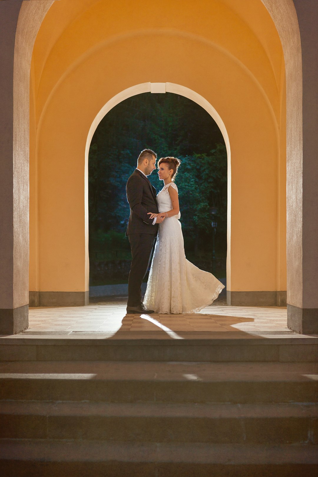 woman in white wedding dress standing on brown concrete floor during daytime