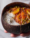 Hands holding a bowl of vibrant sattvik food, glowing with natural freshness.