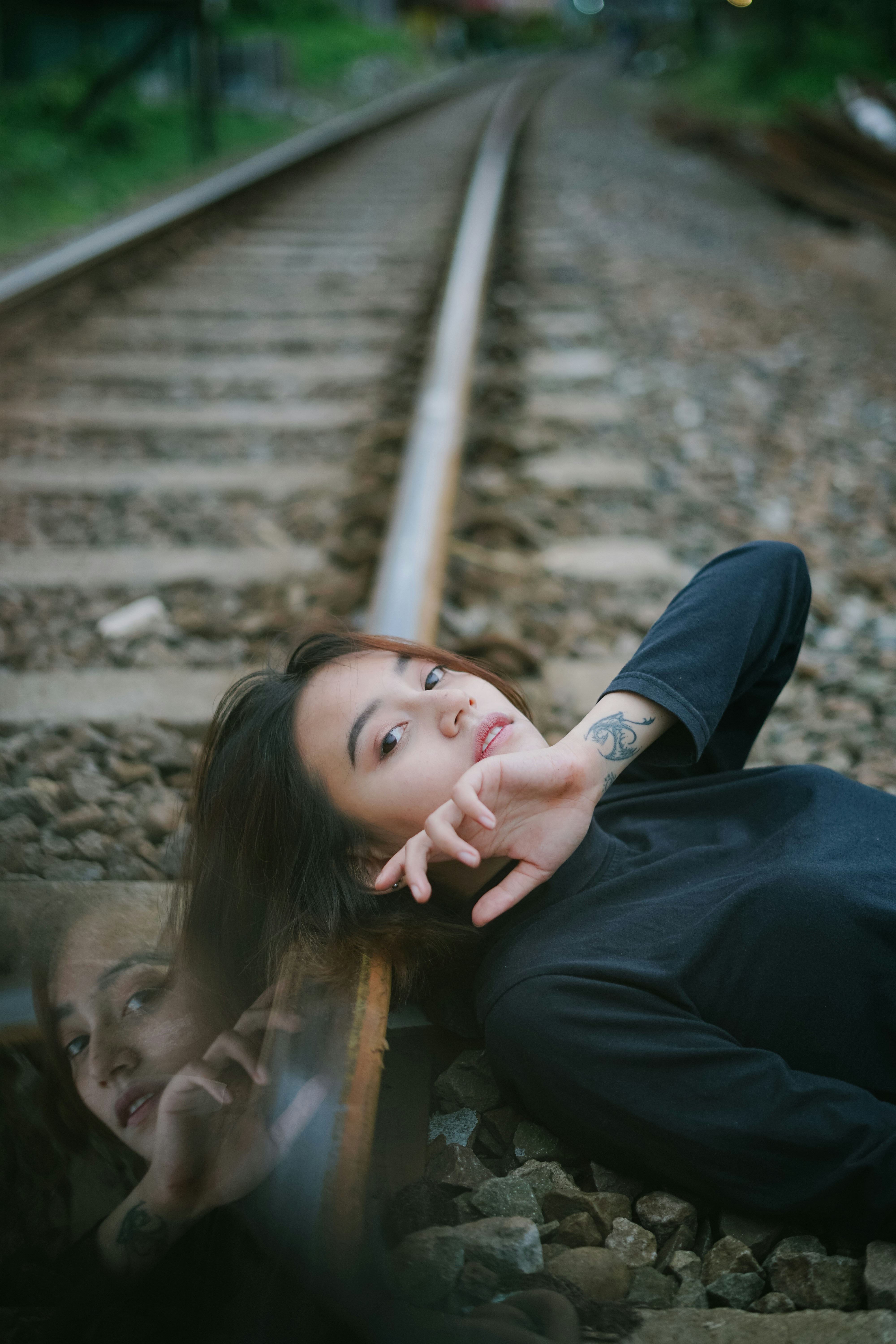 woman in black long sleeve shirt lying on brown wooden stairs