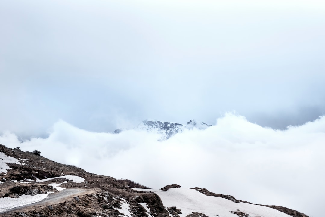 snow covered mountain under white clouds