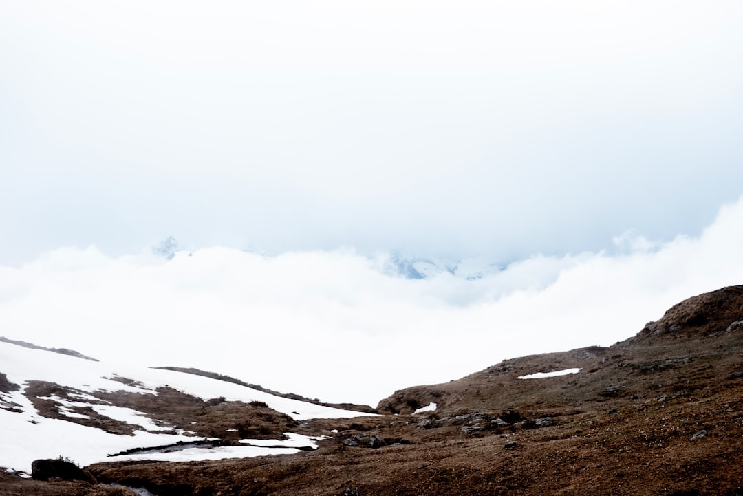 brown and gray mountains under white clouds during daytime