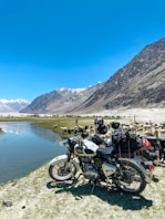 black motorcycle parked near lake during daytime