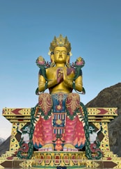 gold hindu deity statue under blue sky during daytime
