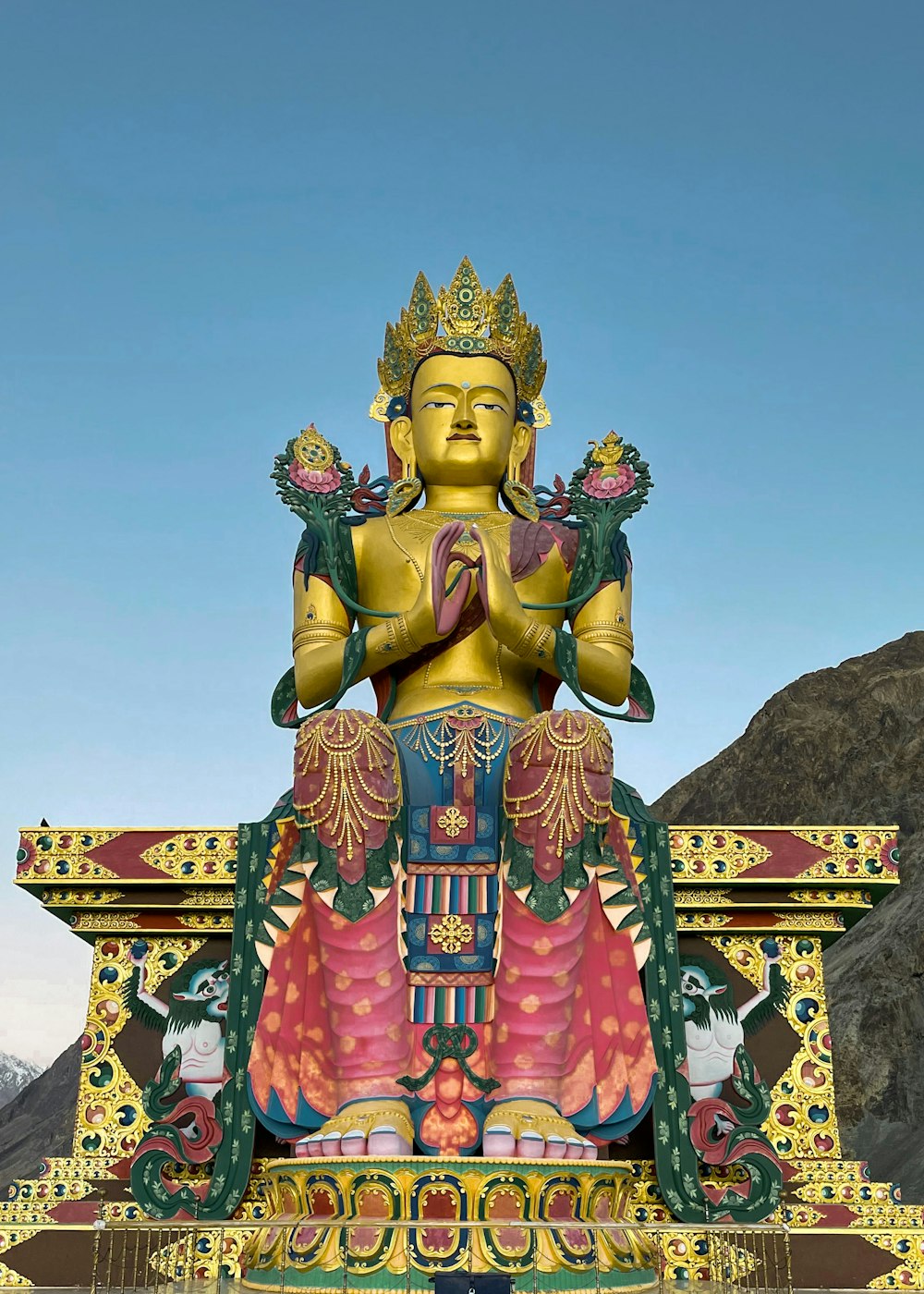 昼間の青空の下で金色のヒンドゥー教の神像