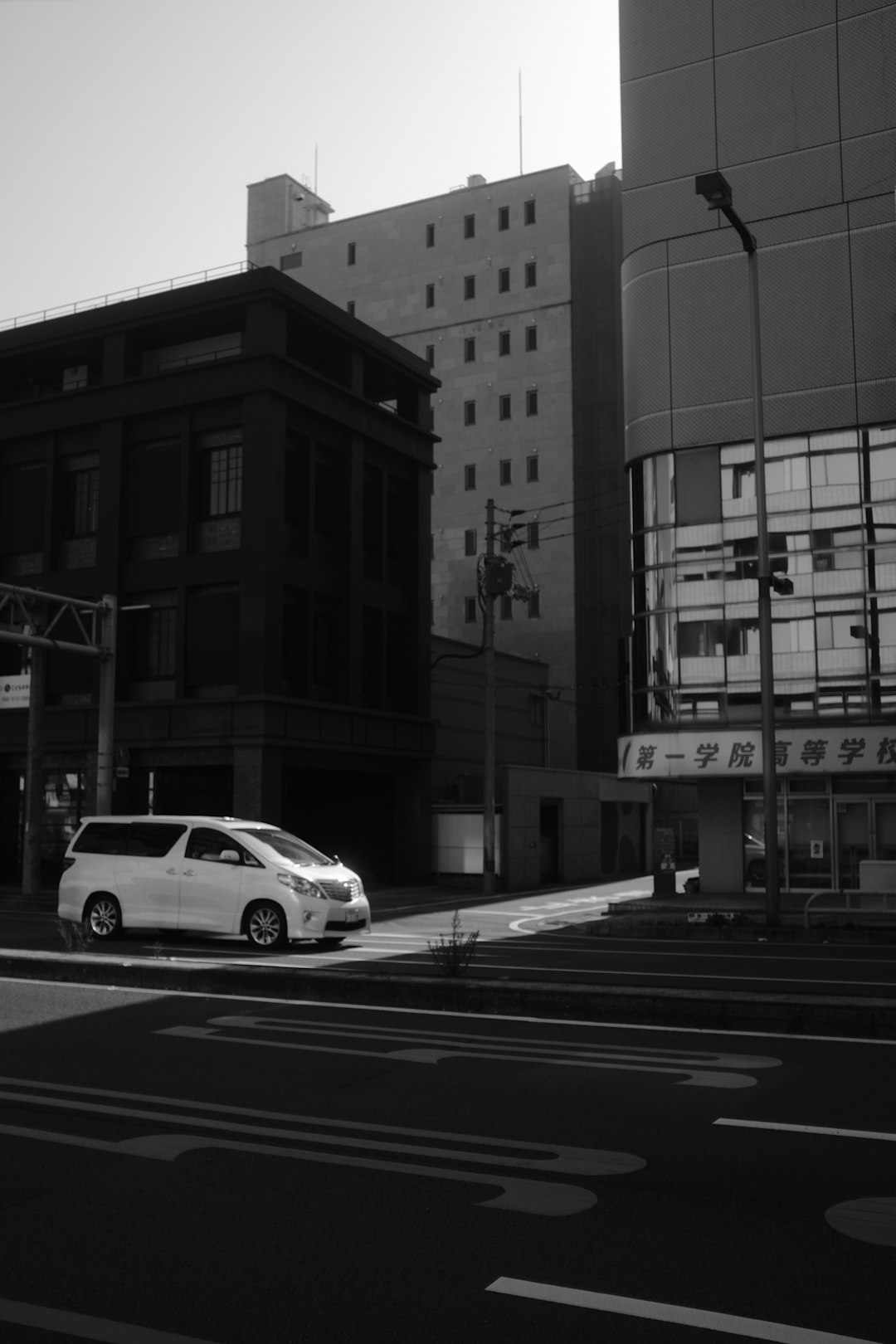 grayscale photo of cars on road near building