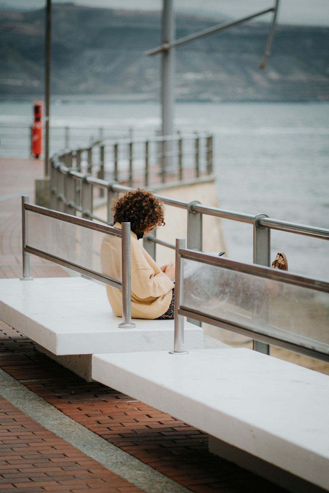 woman in white dress sitting on white concrete bench