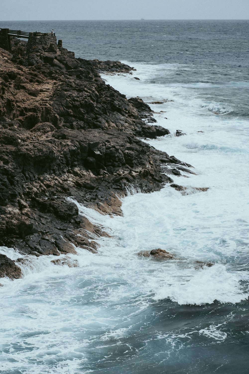 ocean waves crashing on rocky shore during daytime