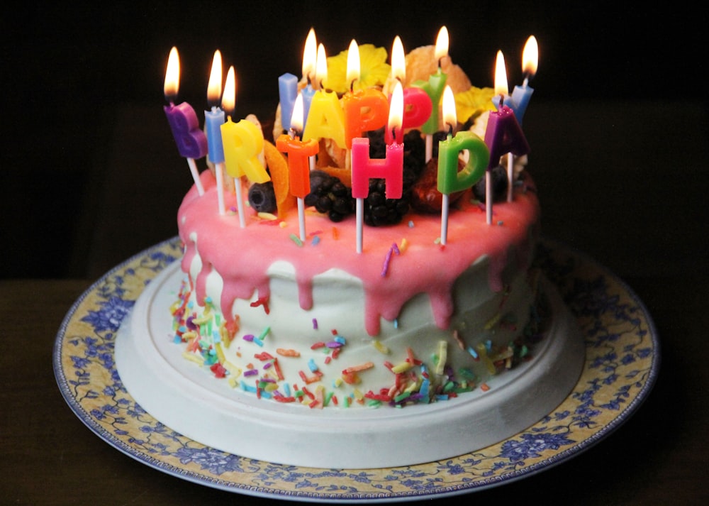 white and pink cake with candles