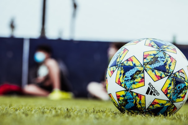 white blue and red soccer ball on green grass field during daytime