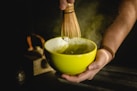 person holding green ceramic bowl