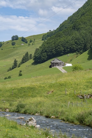 A serene farm landscape with rolling hills and a barn.