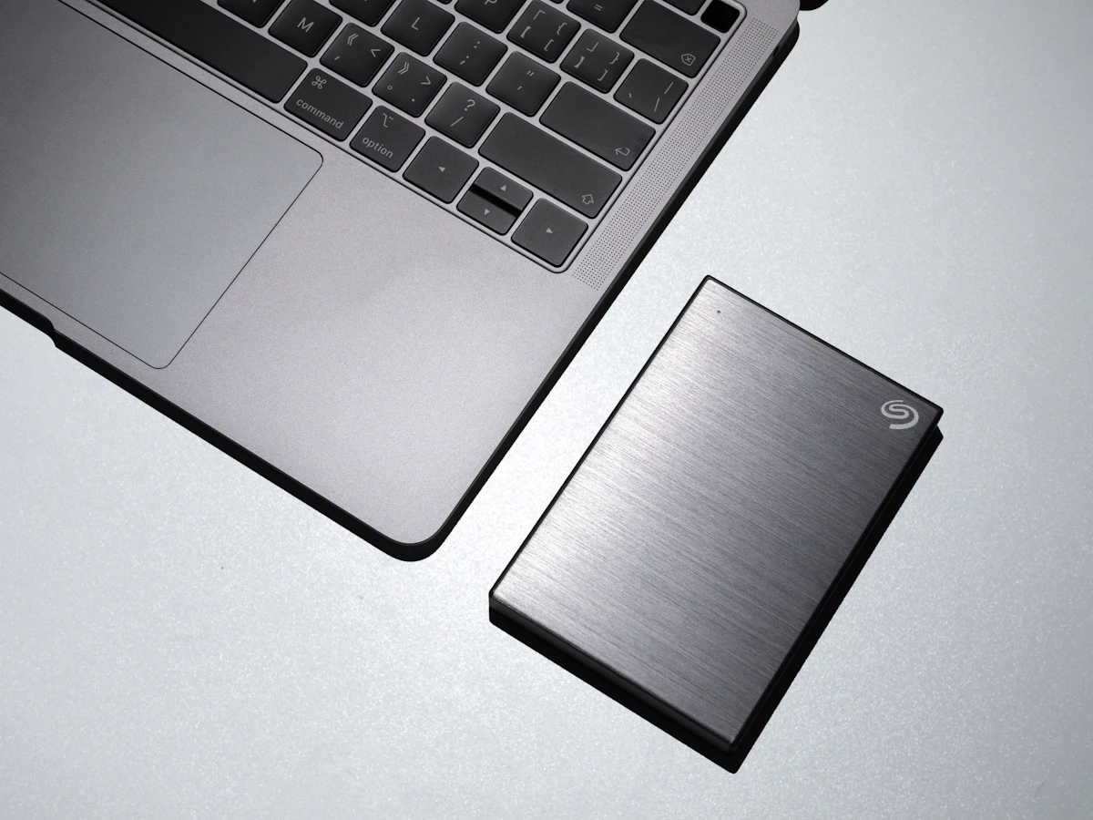 A slim external drive beside a laptop keyboard