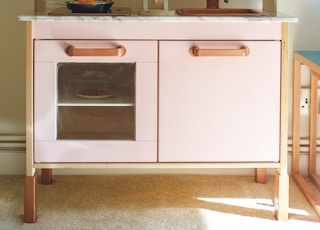 white wooden kitchen cabinet with stainless steel cooking pot