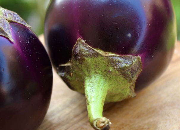 purple round fruit on brown wooden table