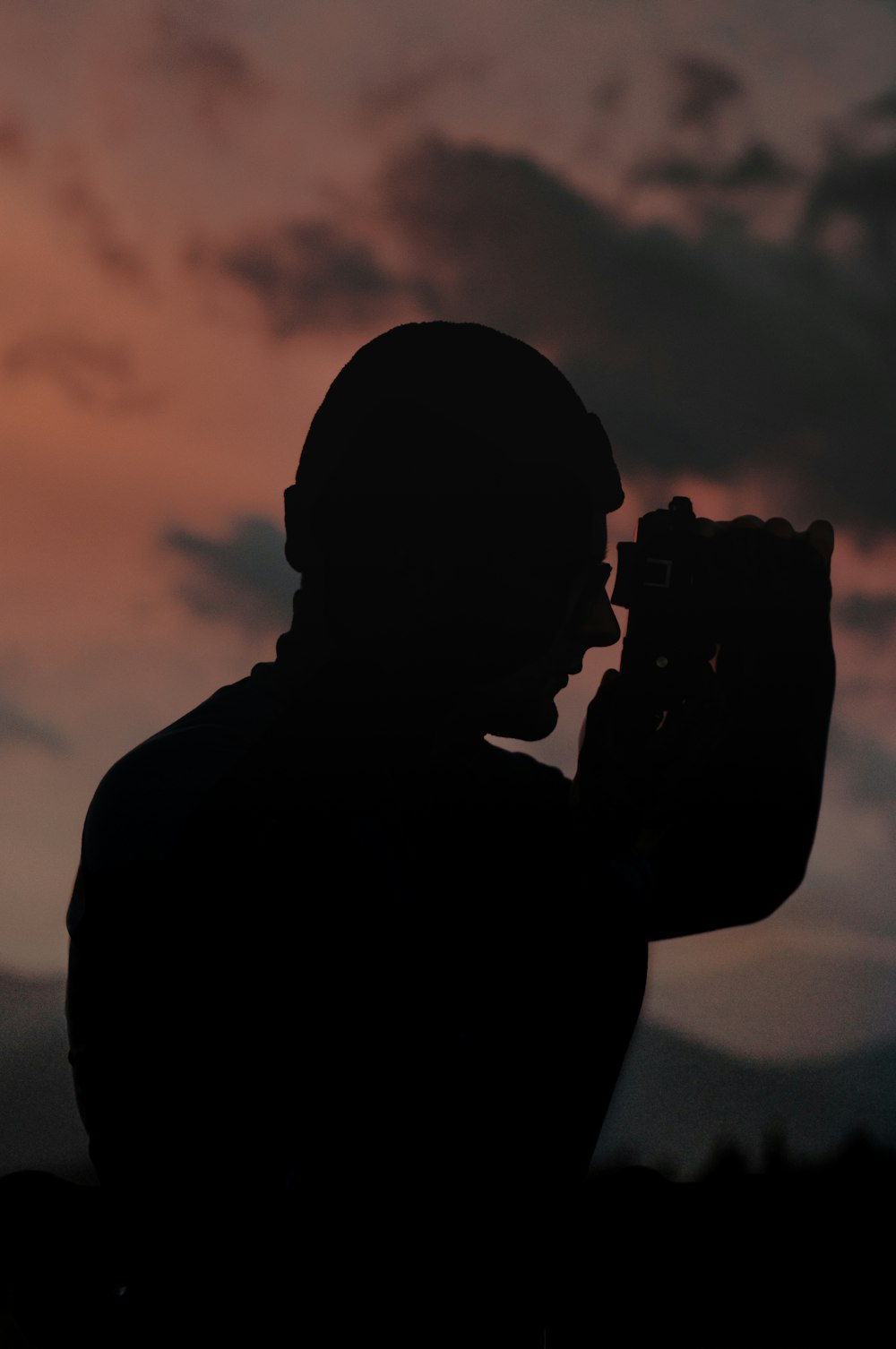 silhouette of man holding camera