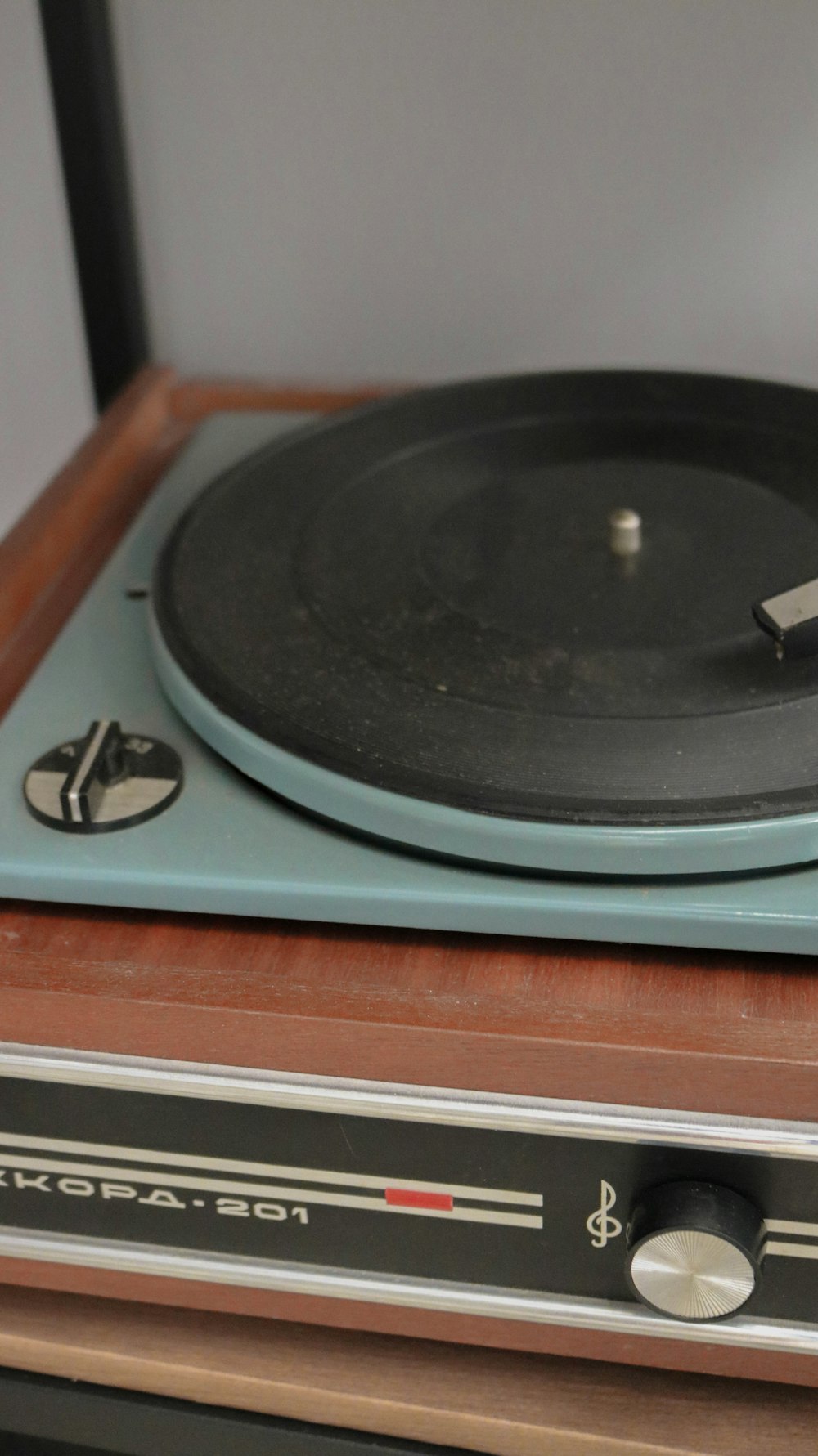 schwarzer Vinyl-Plattenspieler auf braunem Holztisch