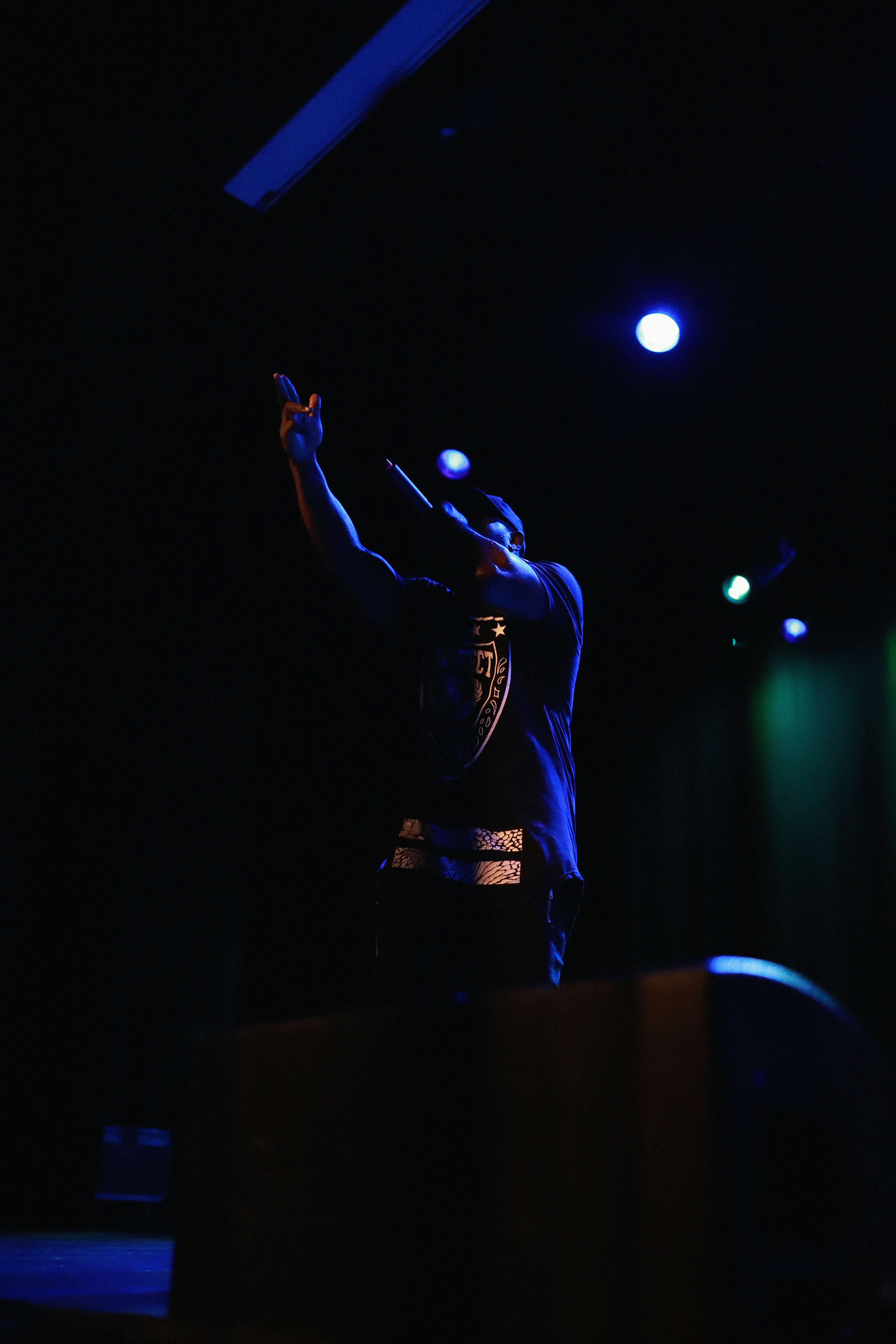 man in black long sleeve shirt standing on stage