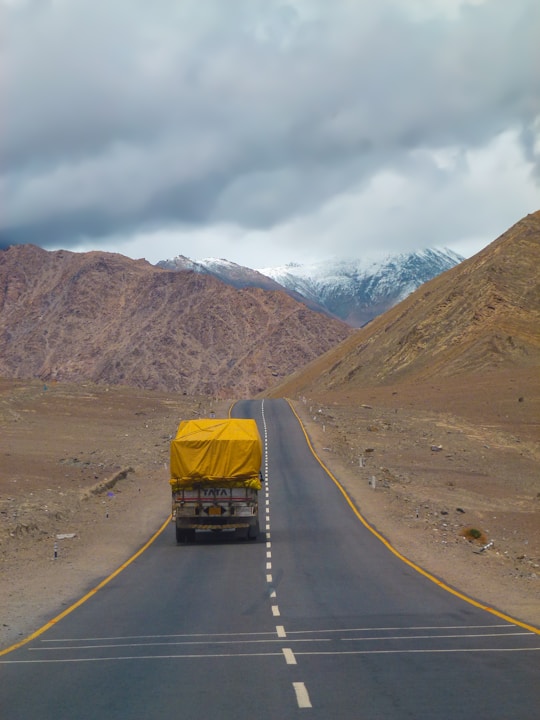 yellow car on road near brown mountain during daytime