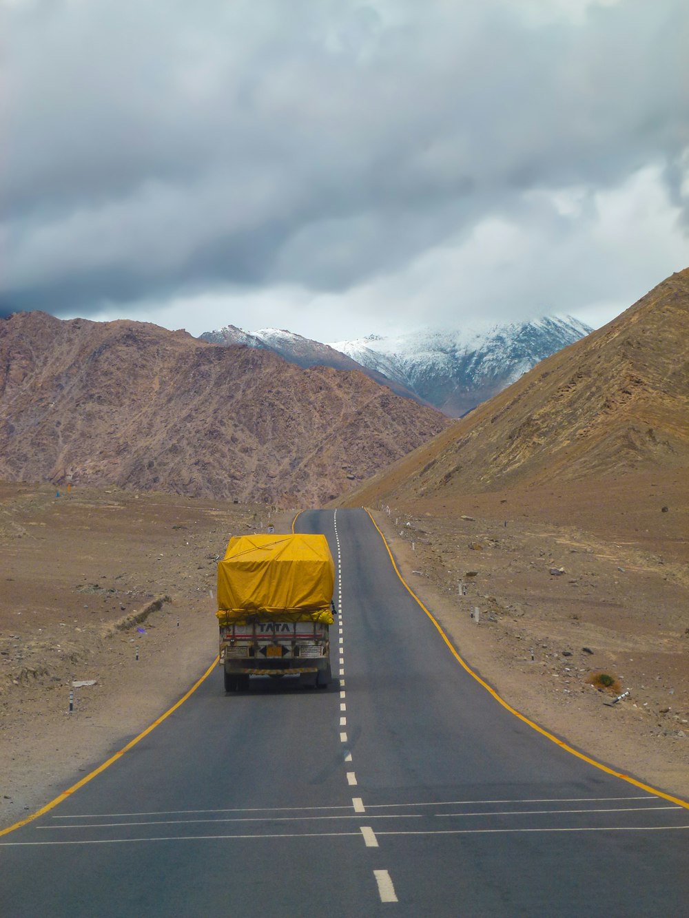 yellow car on road near brown mountain during daytime