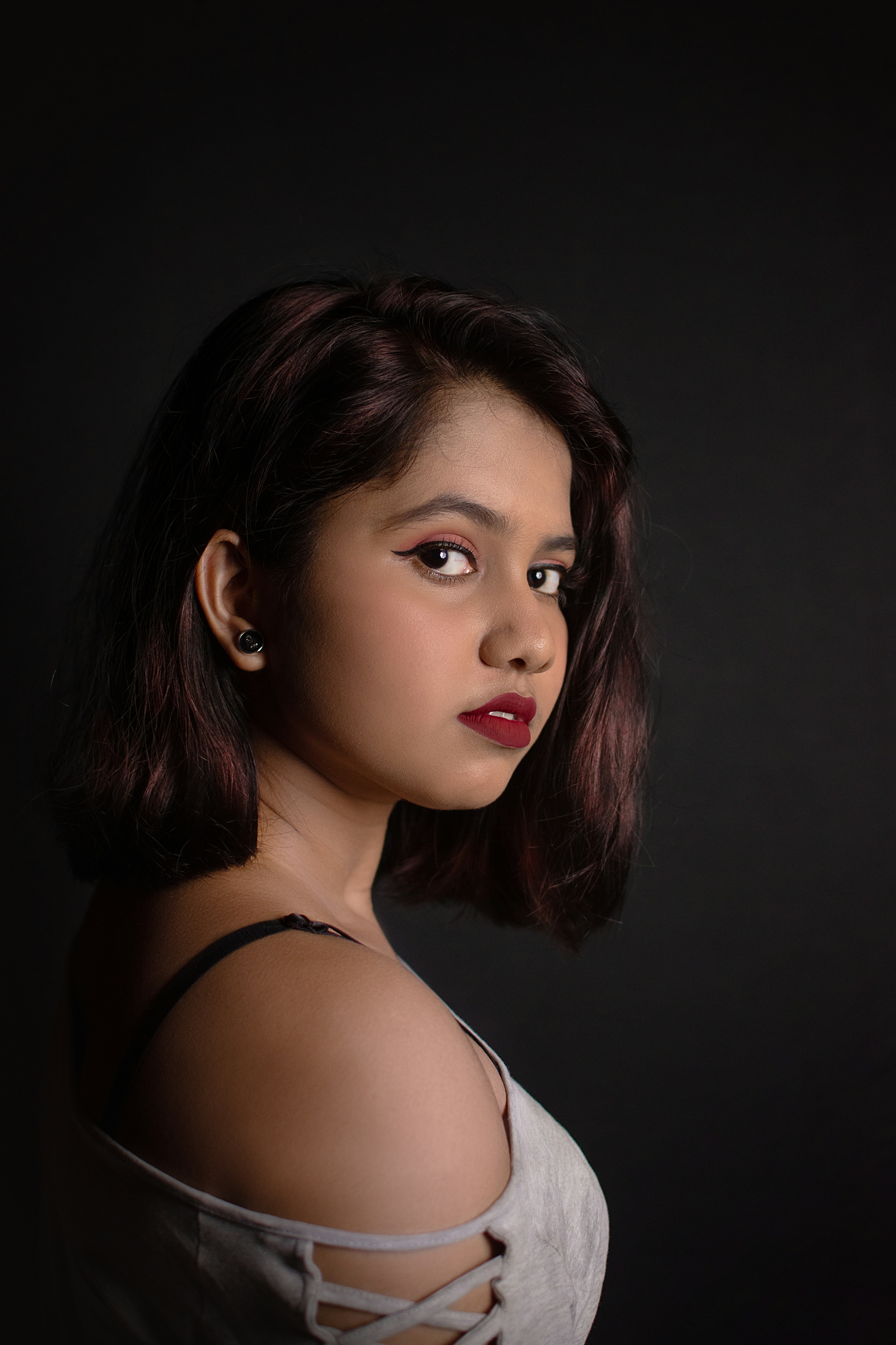 Woman with red lipstick and an off-shoulder dress giving a intense look