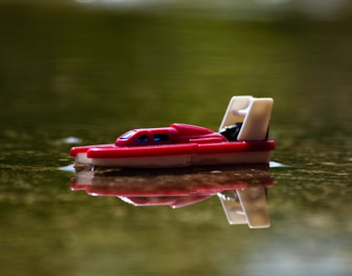 red and white plastic boat on water