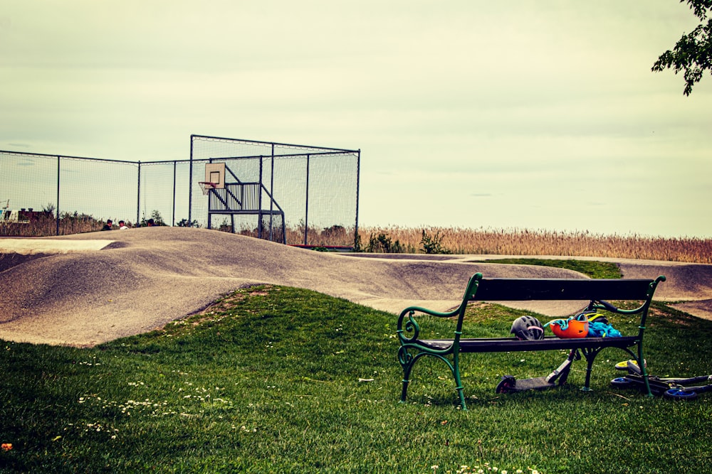 black wooden bench on green grass field near black metal fence during daytime