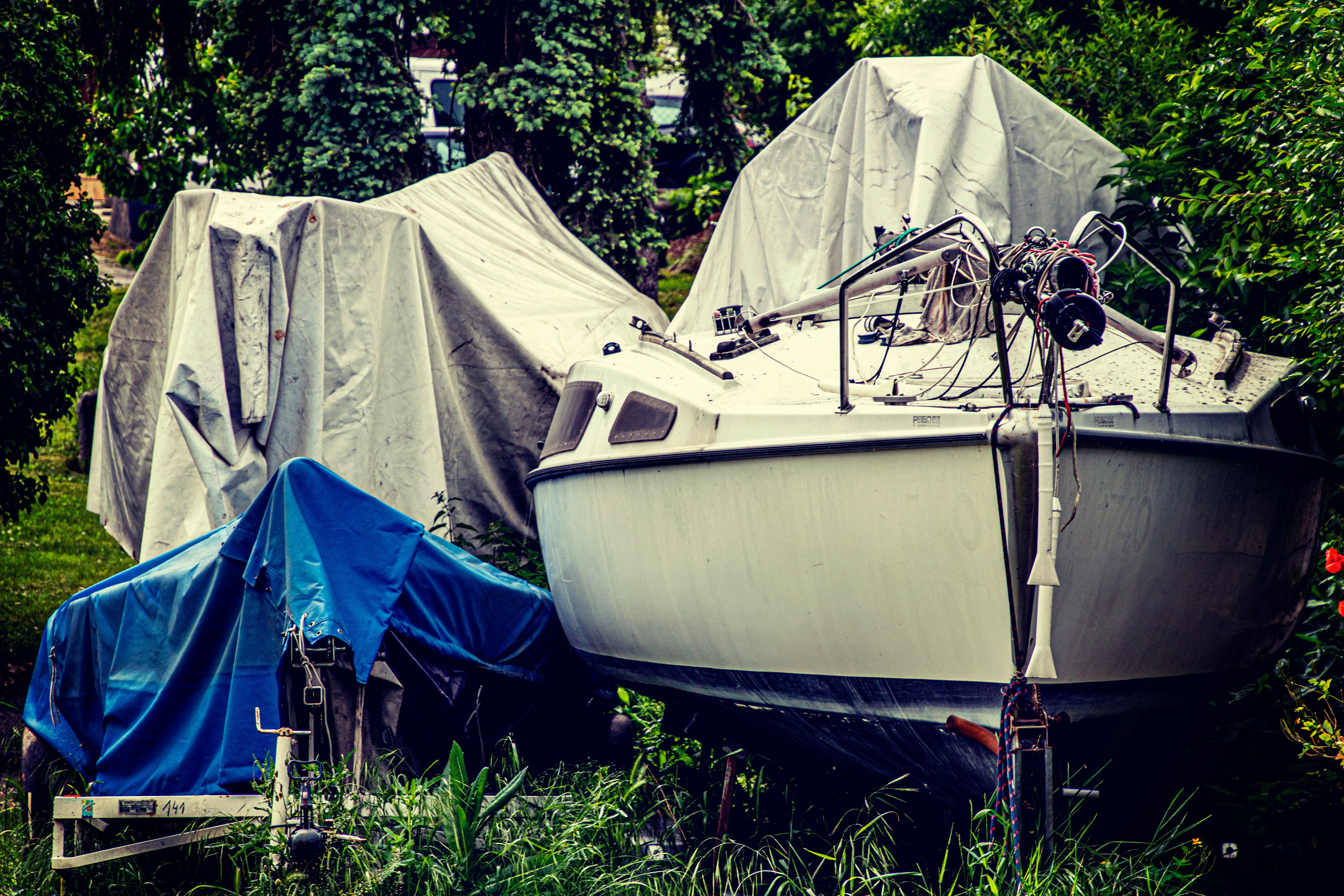 white and blue boat on green grass during daytime