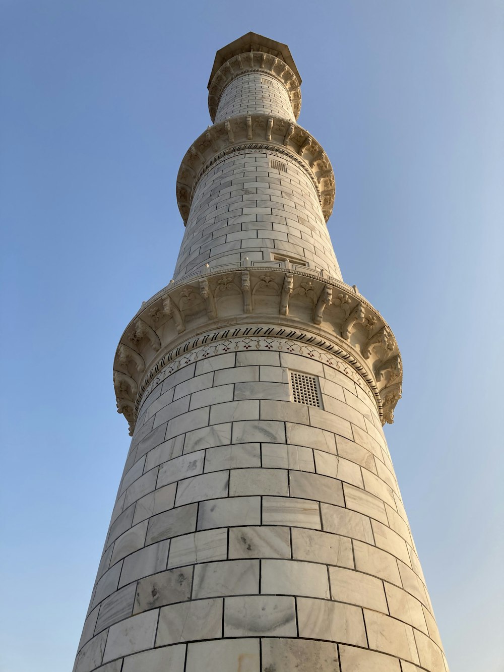 low angle photography of white and black tower under blue sky during daytime