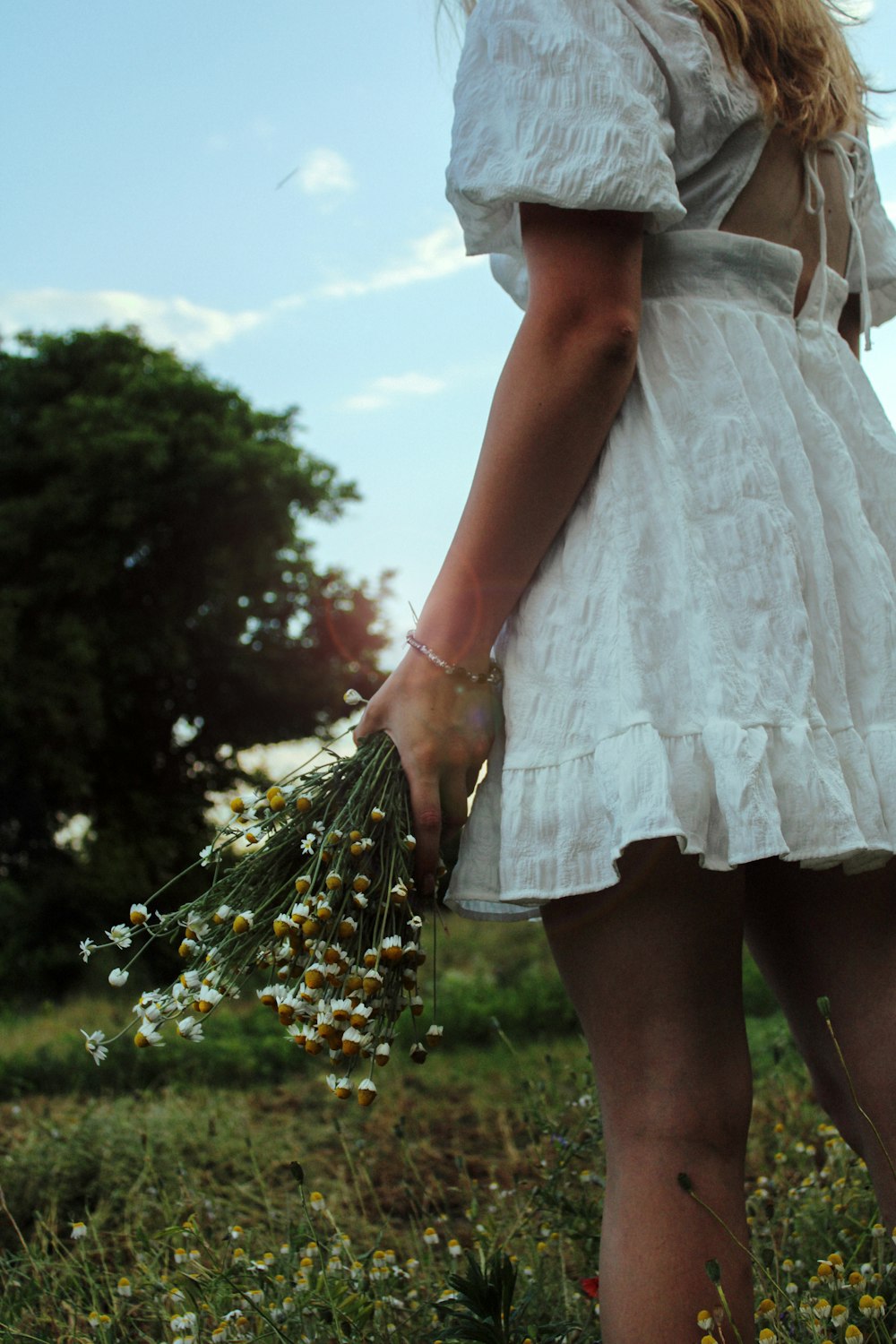 woman in white dress holding bouquet of flowers