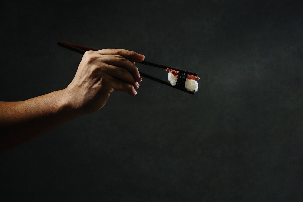 person holding brown wooden pencil