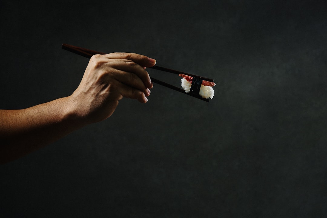 person holding brown wooden pencil, sashimi de polvo