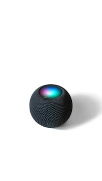 Close-up of a modern smart speaker with glowing LED indicators.