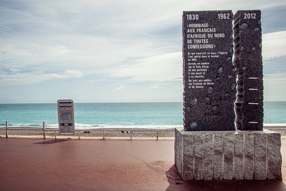 gray concrete post near sea during daytime