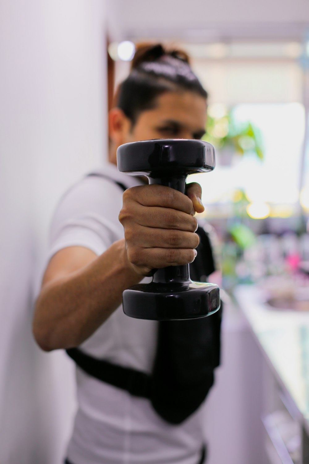 man in white crew neck t-shirt holding black steel pipe