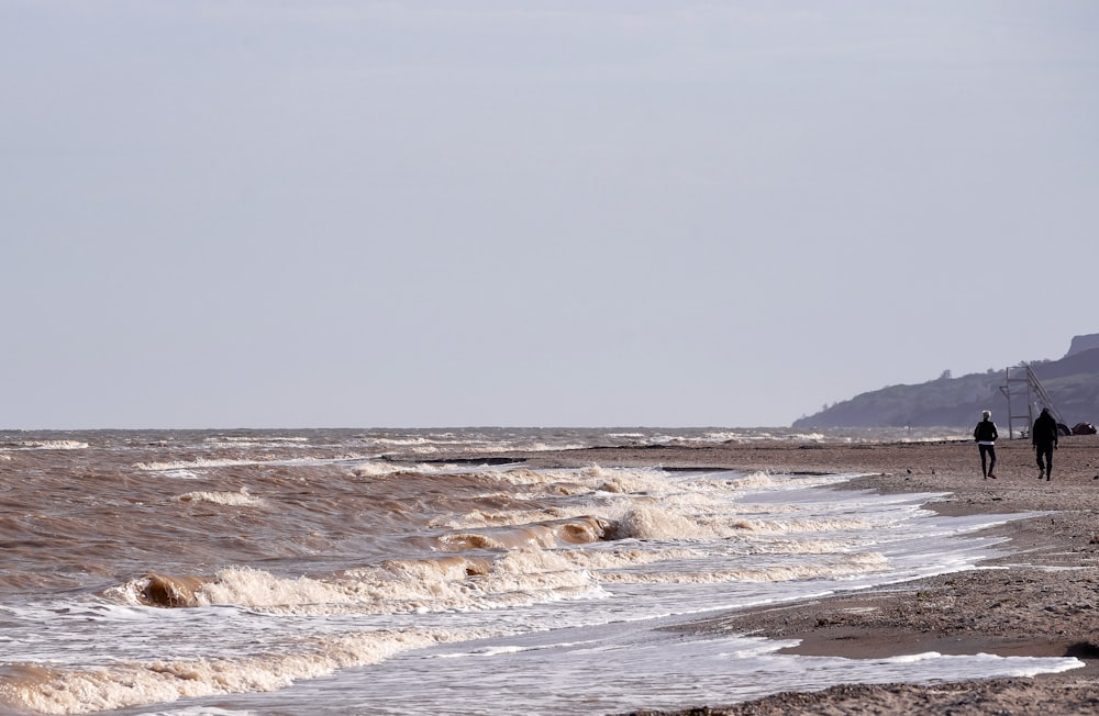 ocean waves crashing on shore during daytime