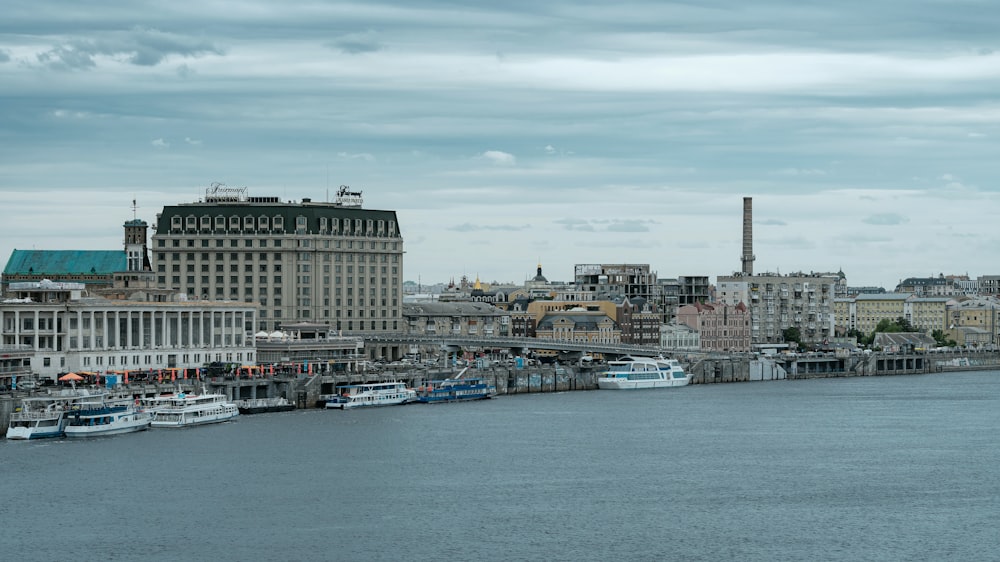 white and blue boat on water near city buildings during daytime