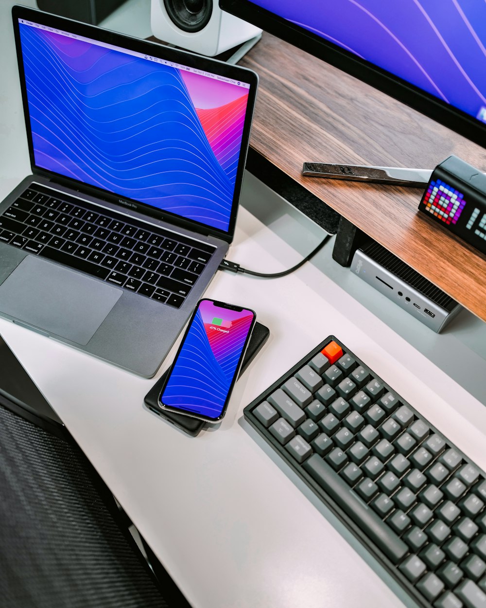 macbook pro beside black iphone 4 on white table