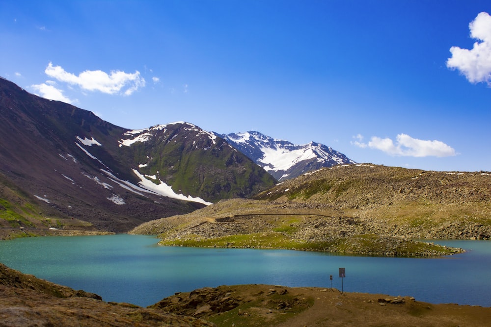 lake in the middle of mountains during daytime