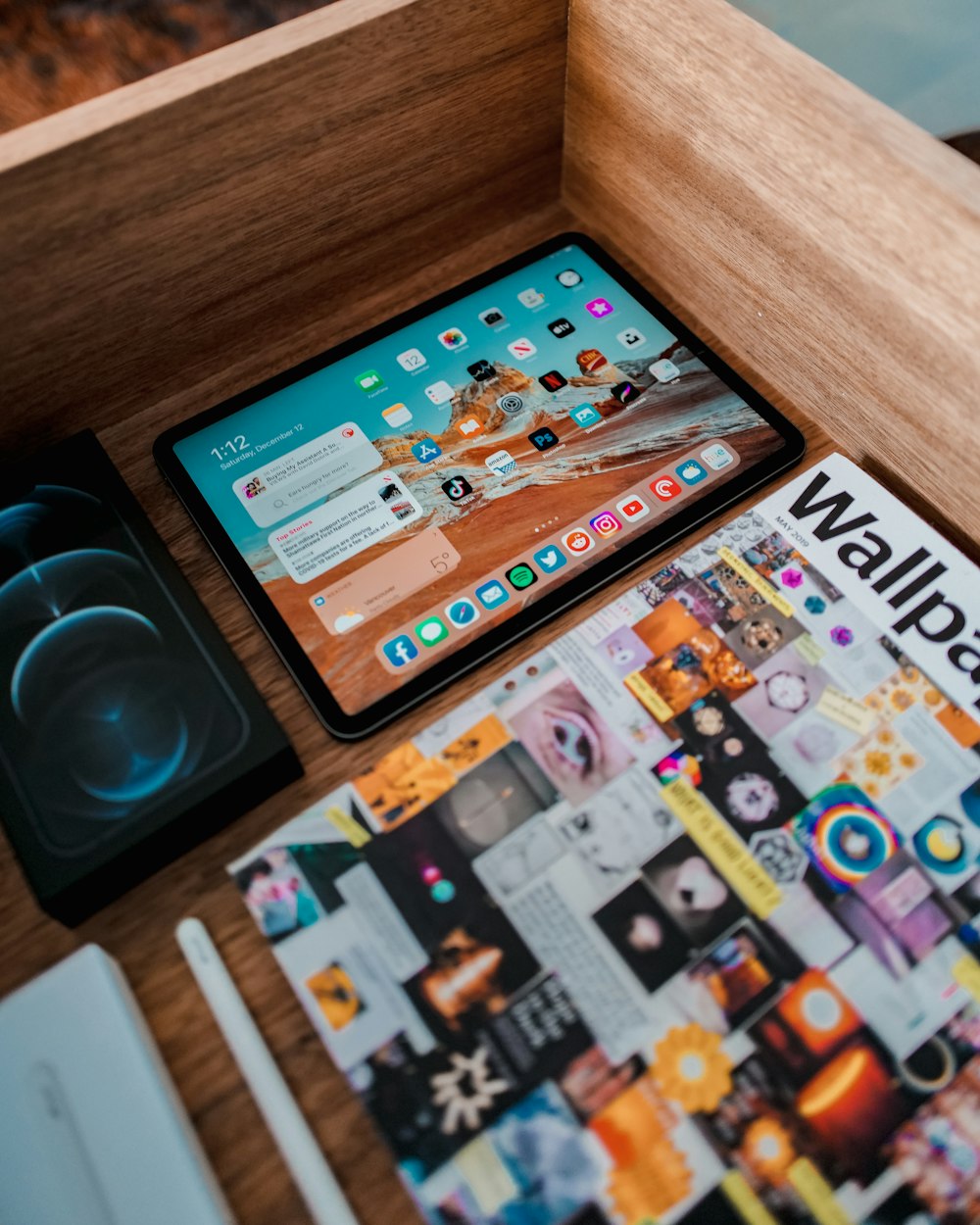 a tablet computer sitting on top of a wooden desk