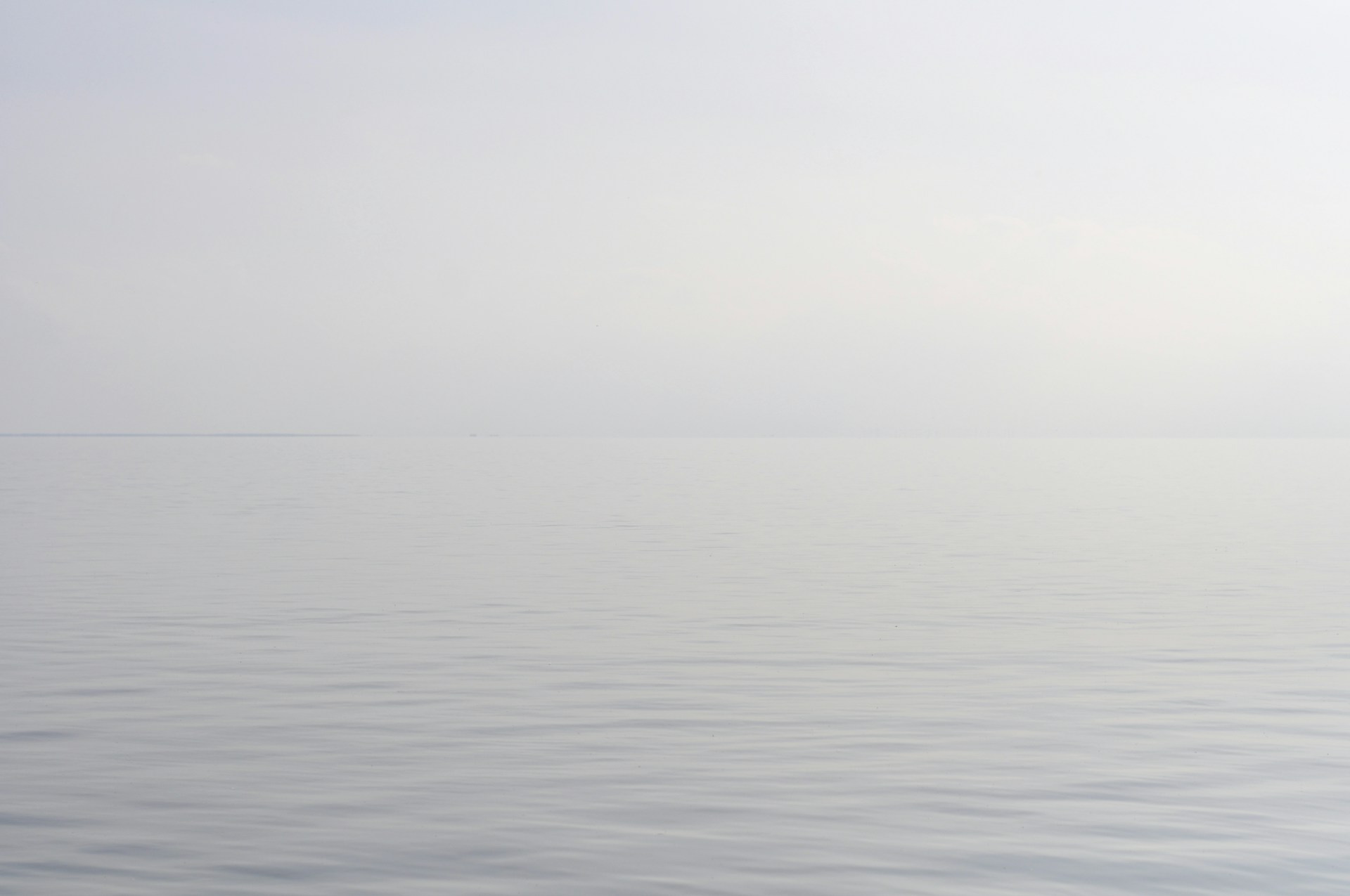 body of water under white sky during daytime