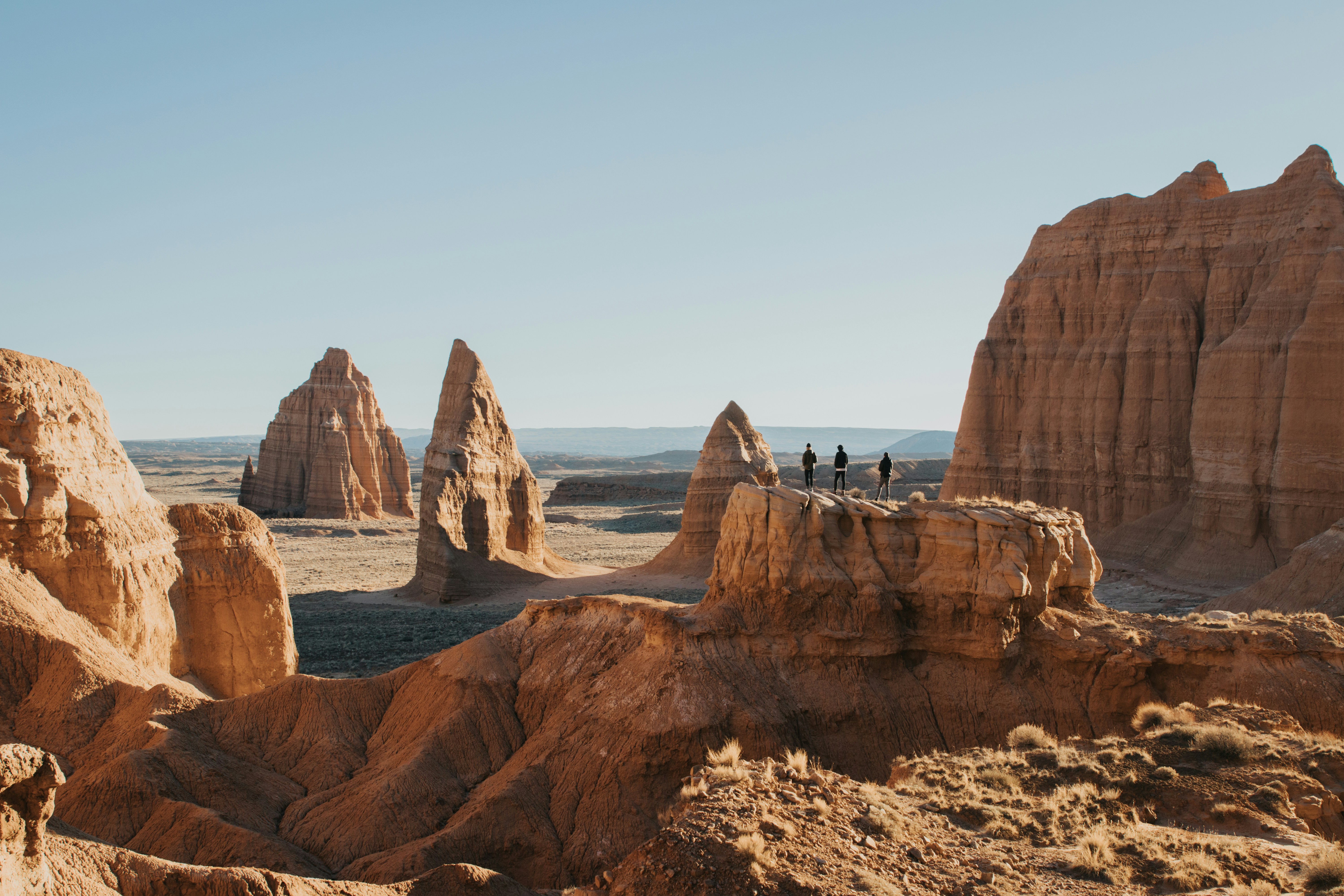 a group of people standing on top of a mountain, Hiking through Cathedral Valley in Capitol Reef National Park.