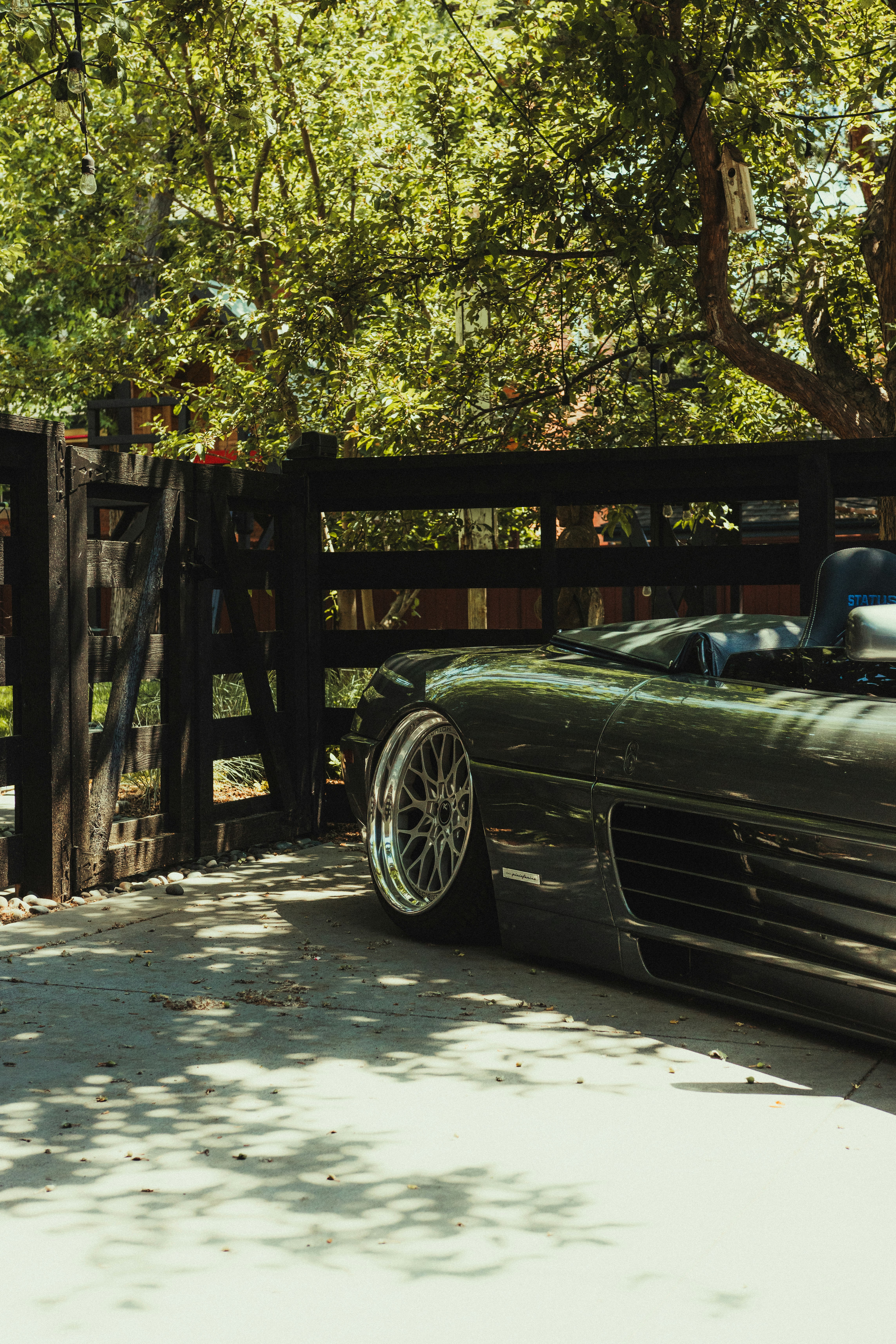 black car parked beside brown wooden fence