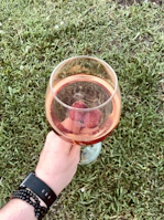 A lifestyle shot of a fan holding a rosévibe drinkware cup with pink and black accents.