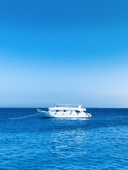 white boat on blue sea under blue sky during daytime