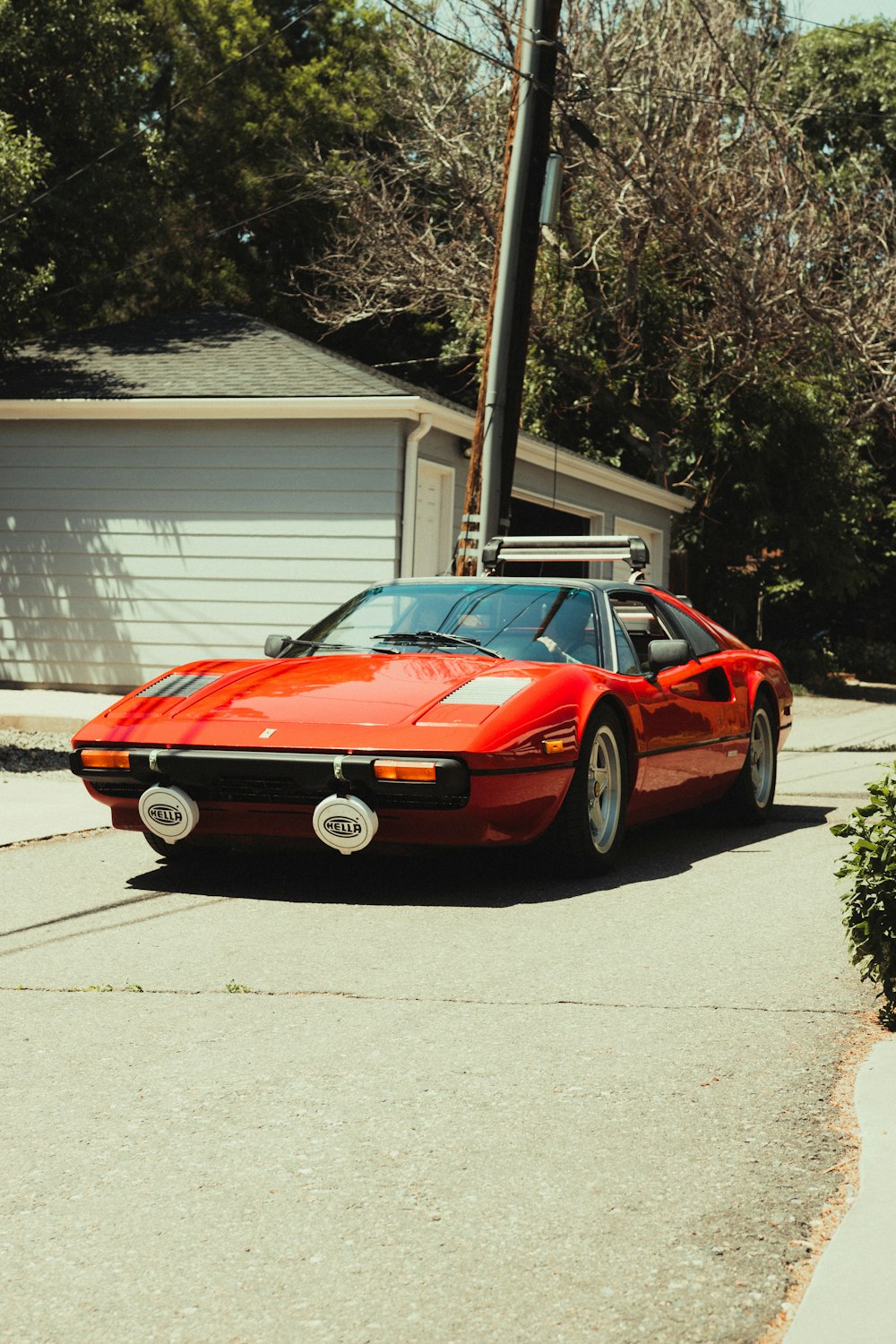 red ferrari coupe parked near white house