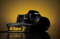 black nikon dslr camera on black surface