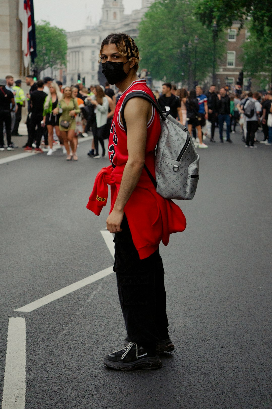 woman in red and black jacket and black pants walking on road during daytime