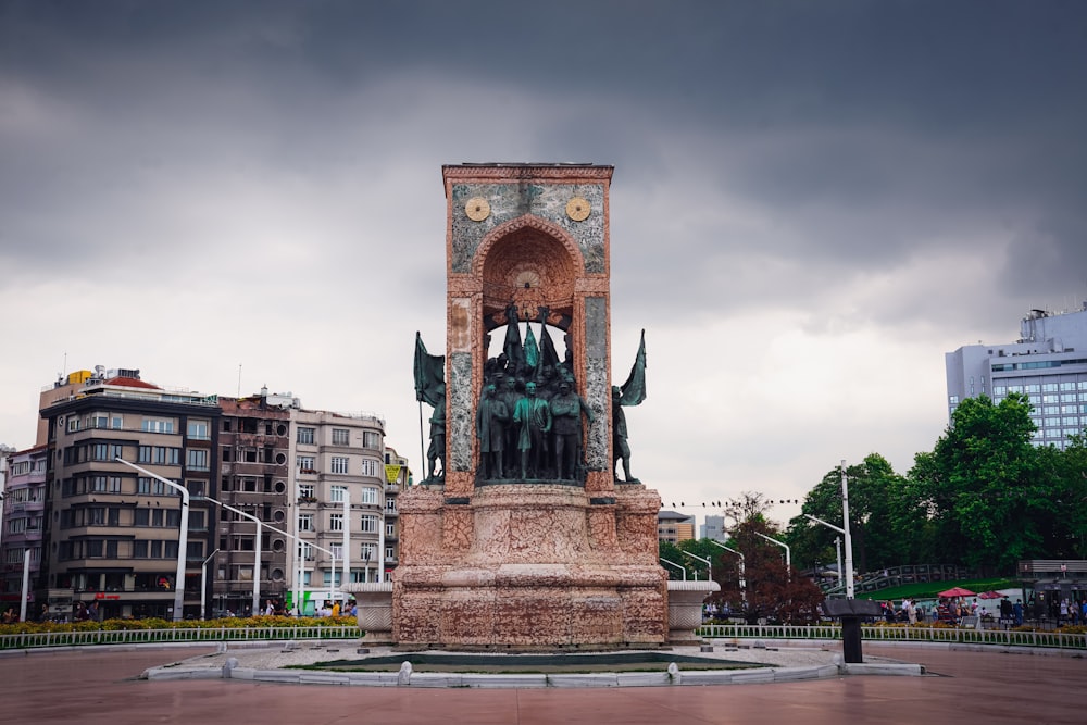 brown concrete statue under gray sky