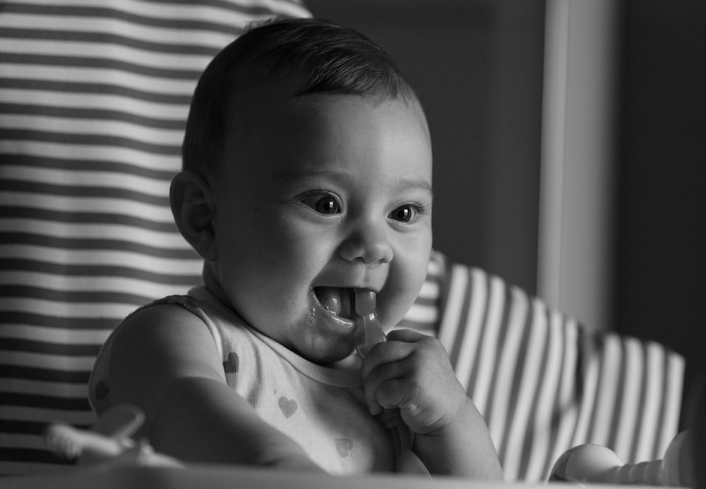 grayscale photo of baby in tank top