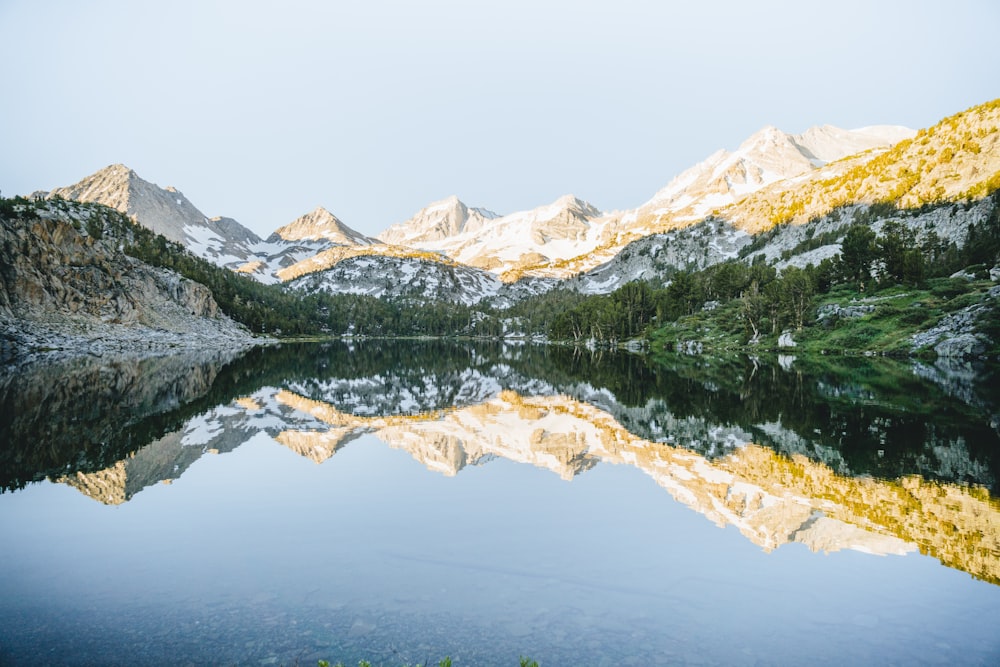 green and white mountains near body of water during daytime